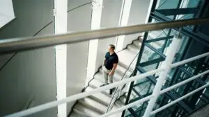 Person walking up a staircase, symbolising a quiet transition from job dependency to independent skill ownership.